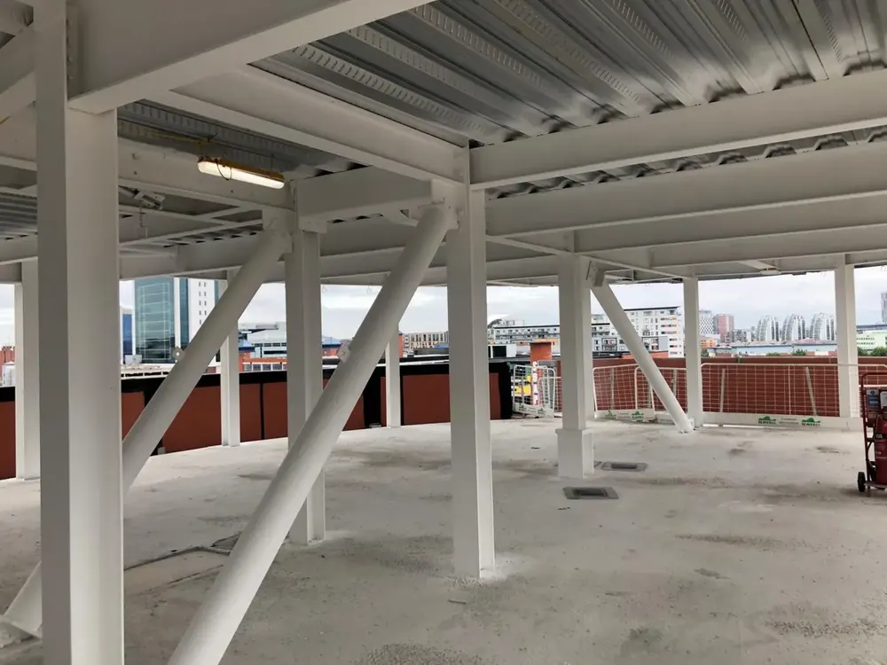 White intumescent-coated steel columns and beams beneath a car park deck